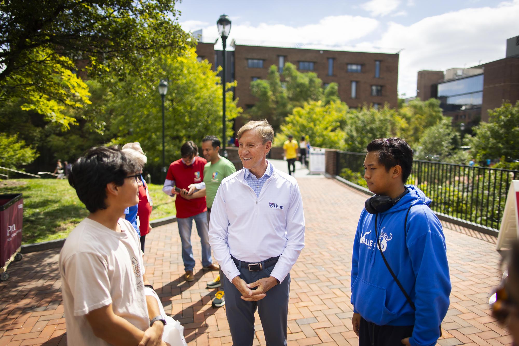 Penn President J. Larry Jameson talks with two students on Penn’s campus during Move-In.