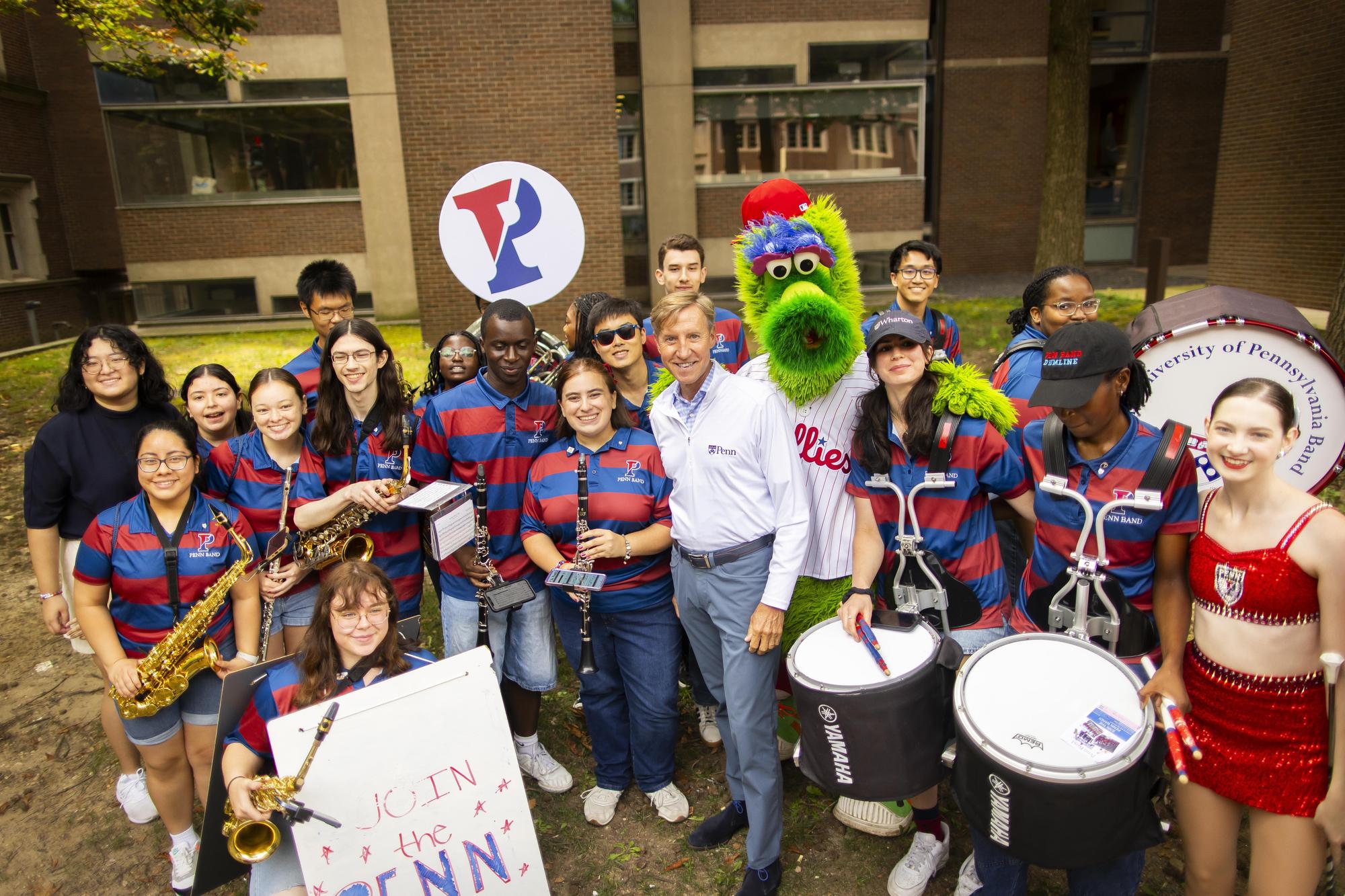 Members of the Penn marching band with the Philly Phanatic and Interim President J. Larry Jameson on Penn’s campus during Move-In.