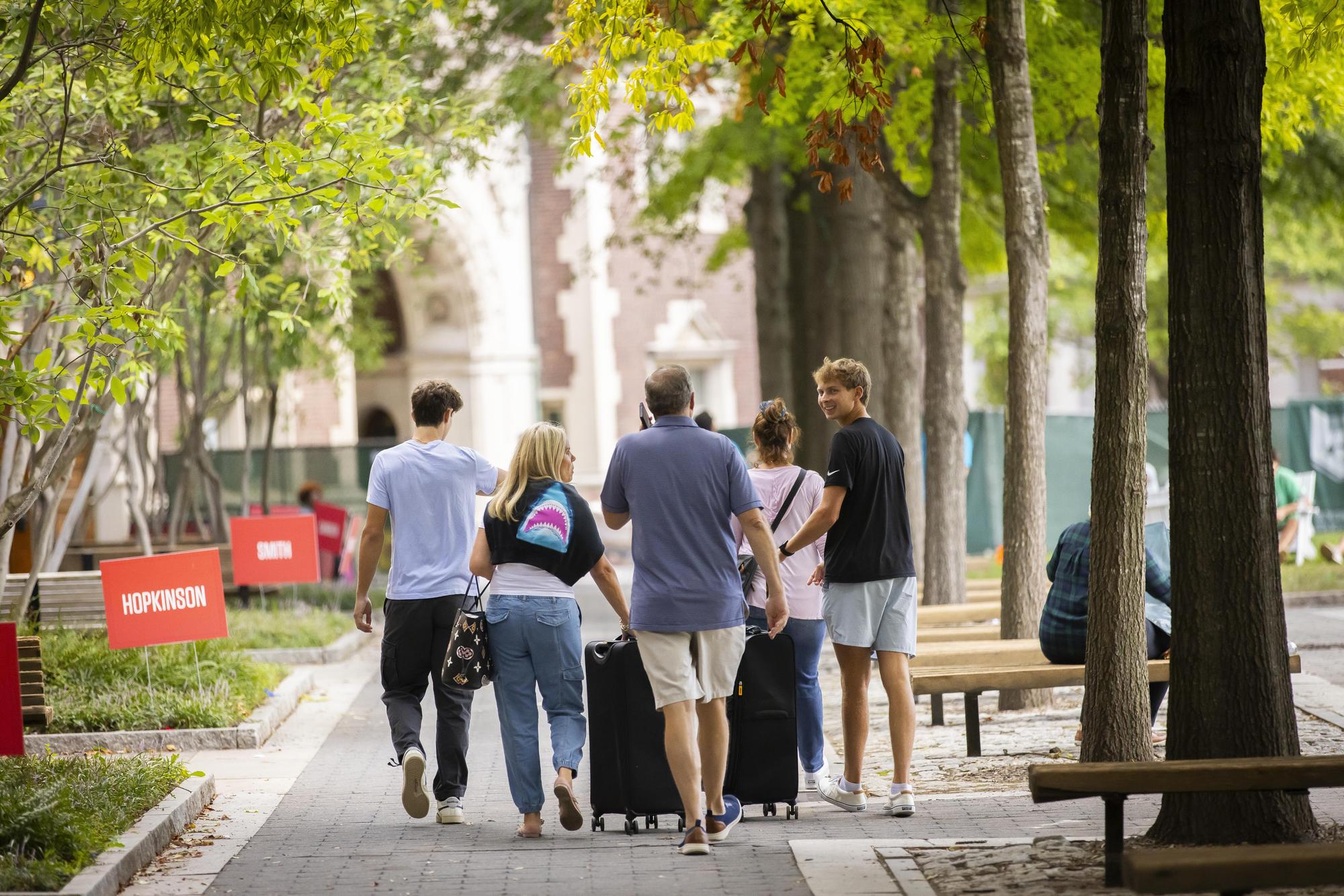 A Penn student and their family walking on Penn’s campus with luggage on Move-In day.