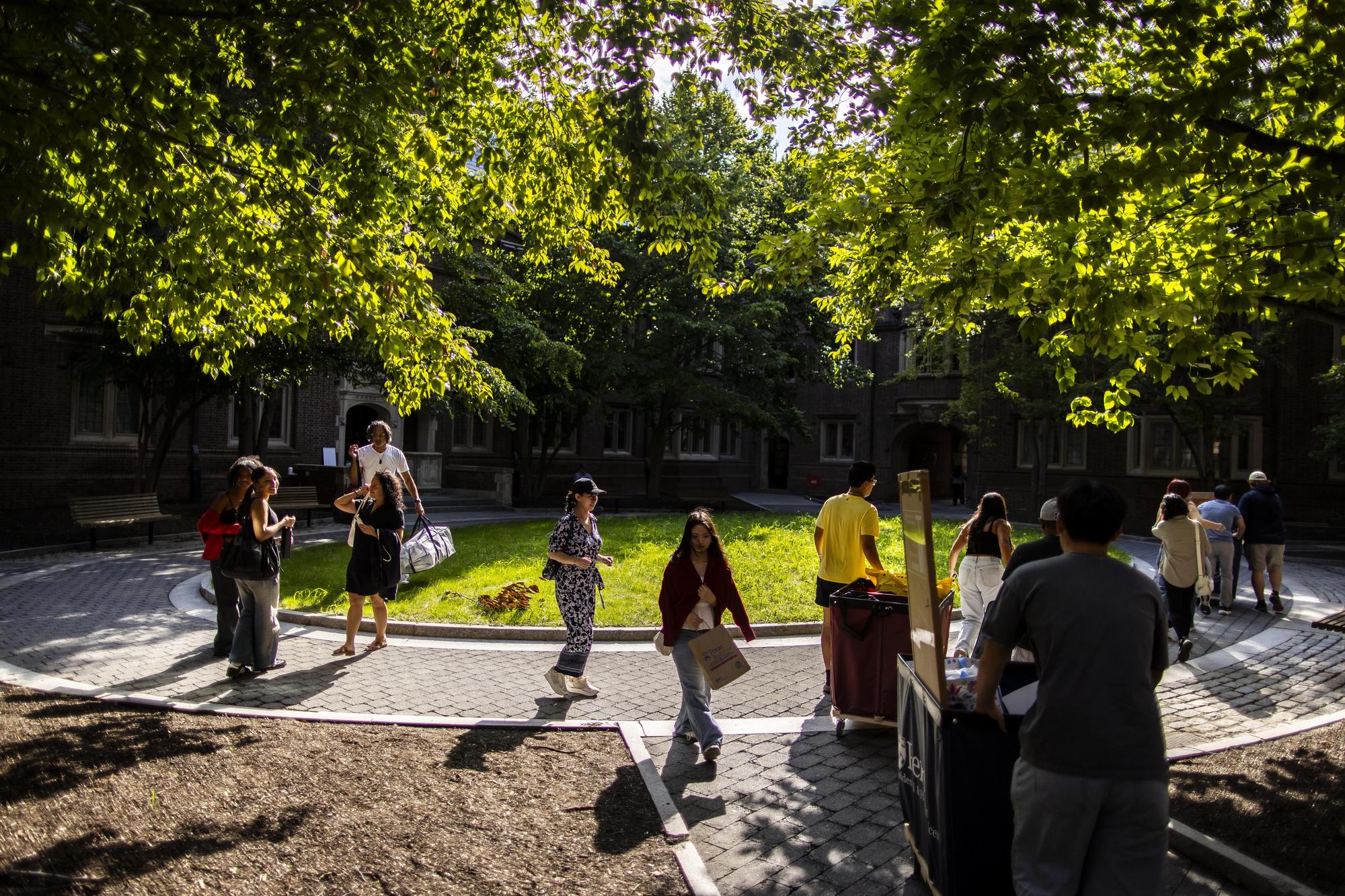 Students and families with Move-In cars outside a dorm on Move-In day.