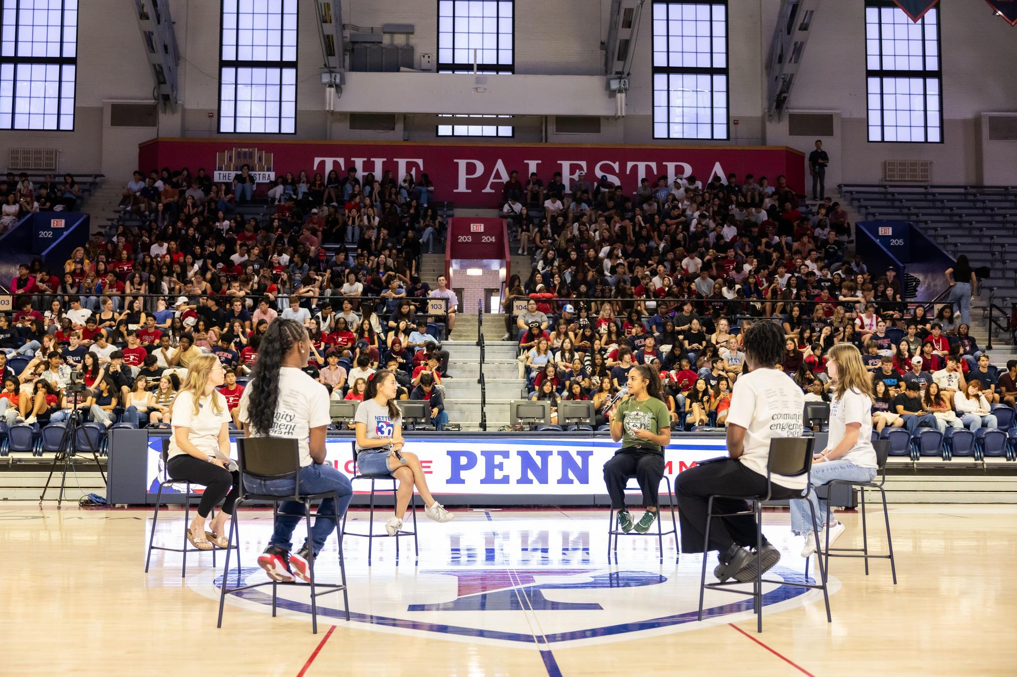 Six people seated on chairs on court at the Palestra on NSO weekend.