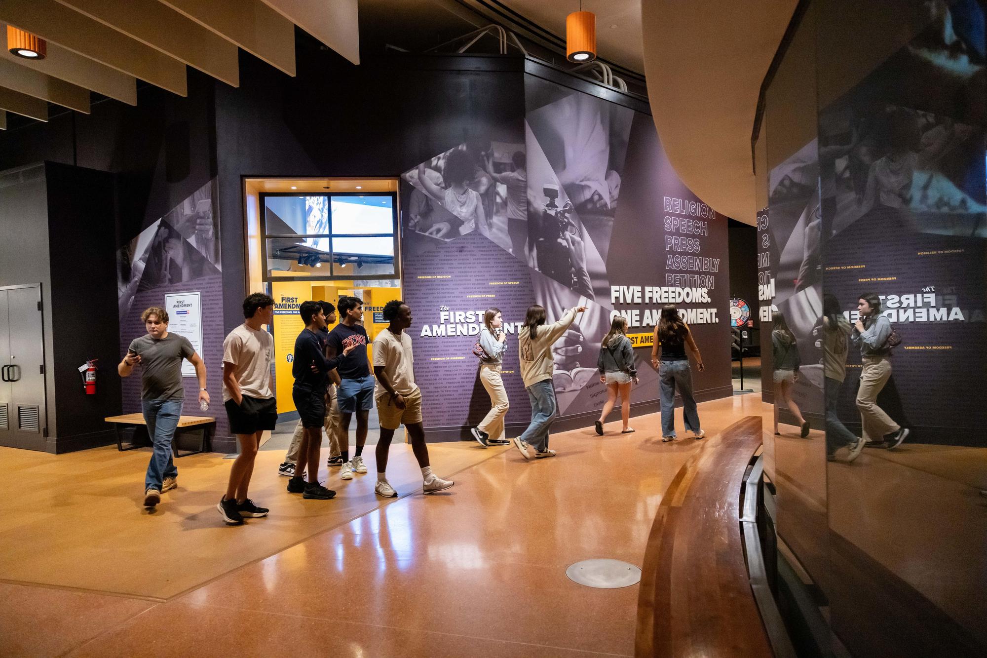 New Penn students walk through a First Amendment gallery at a museum on NSO weekend.