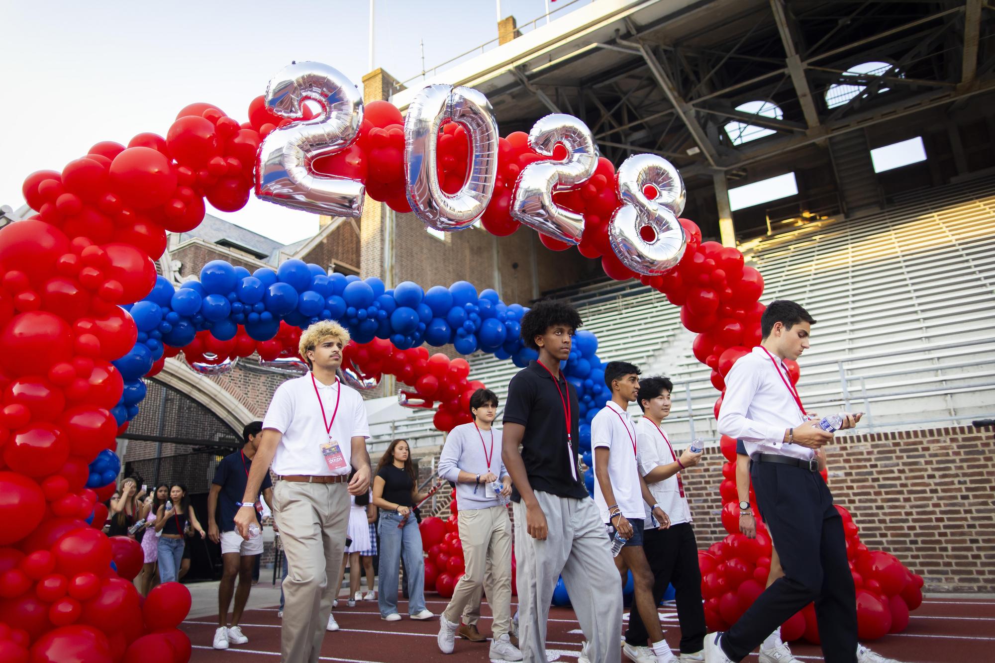 New Penn students walk through a balloon arch reading 2028 at Penn’s Convocation.