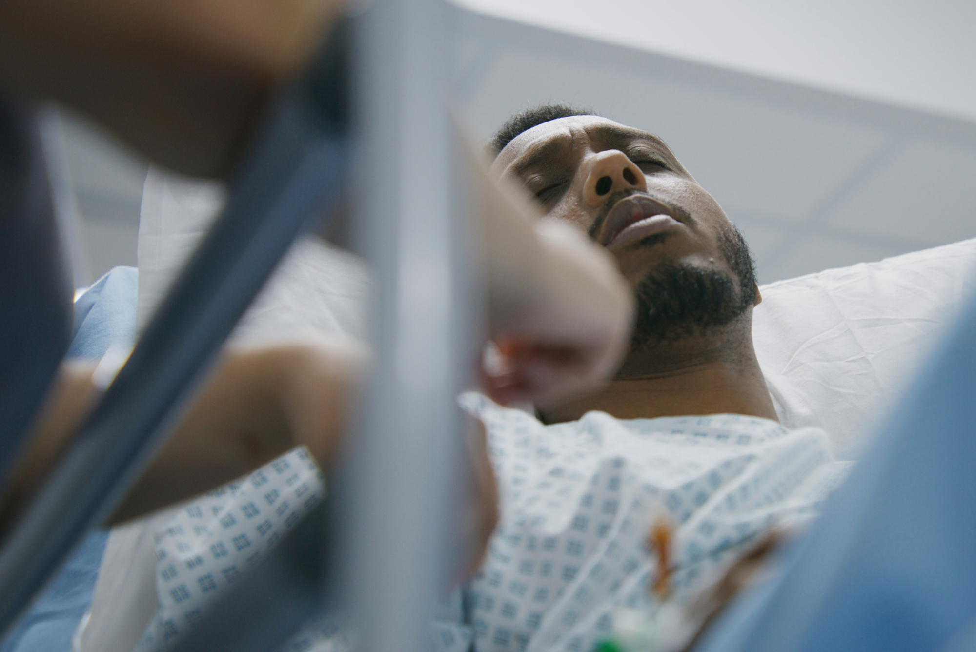 An African American man on a hospital gurney.