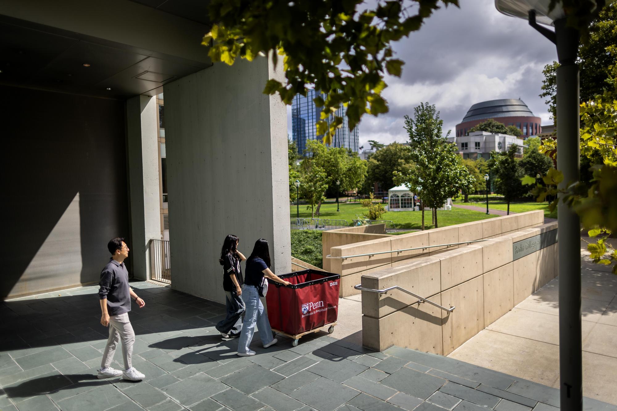 A Penn student and their parents push a Move-In cart out of a dorm on Penn’s campus on Move-In day.