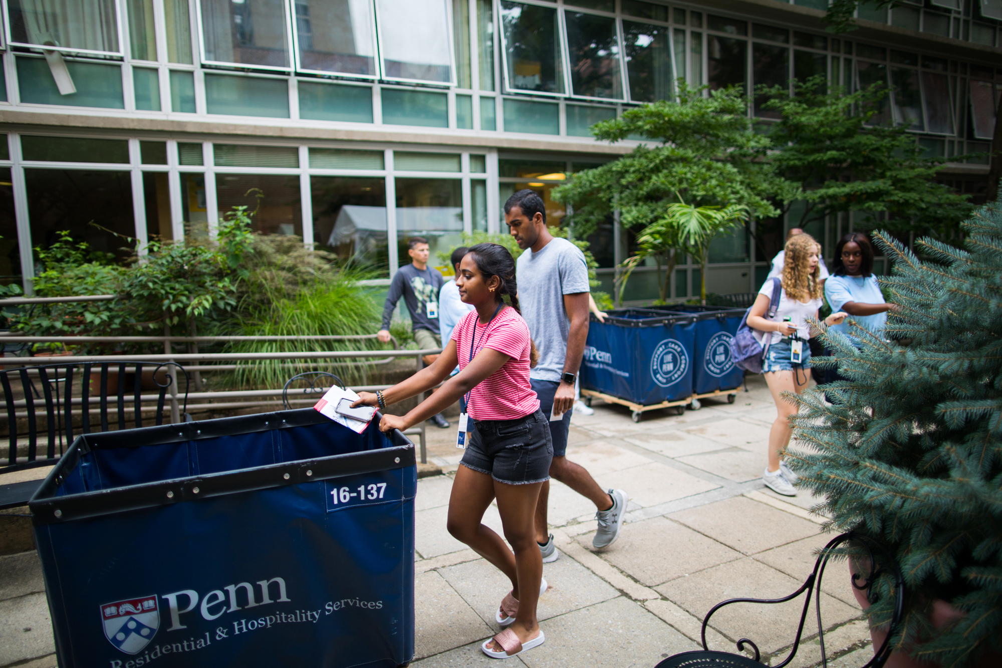 Penn students wheeling Move-In bins outside a dorm.