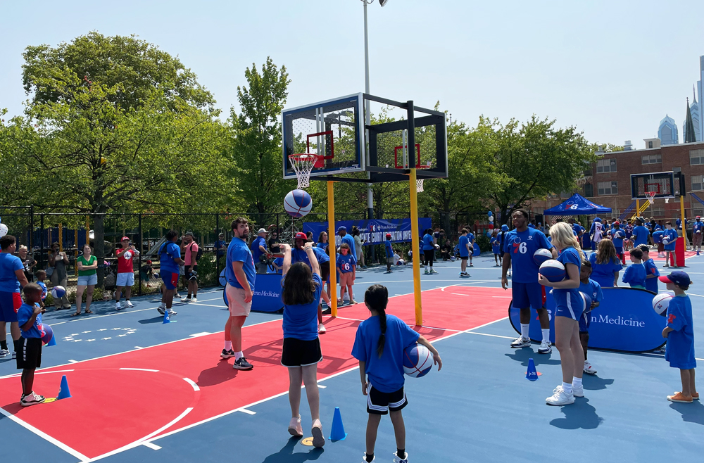 Members of the Penn Medicine community play basketball with kids at the Roberto Clemente Park.