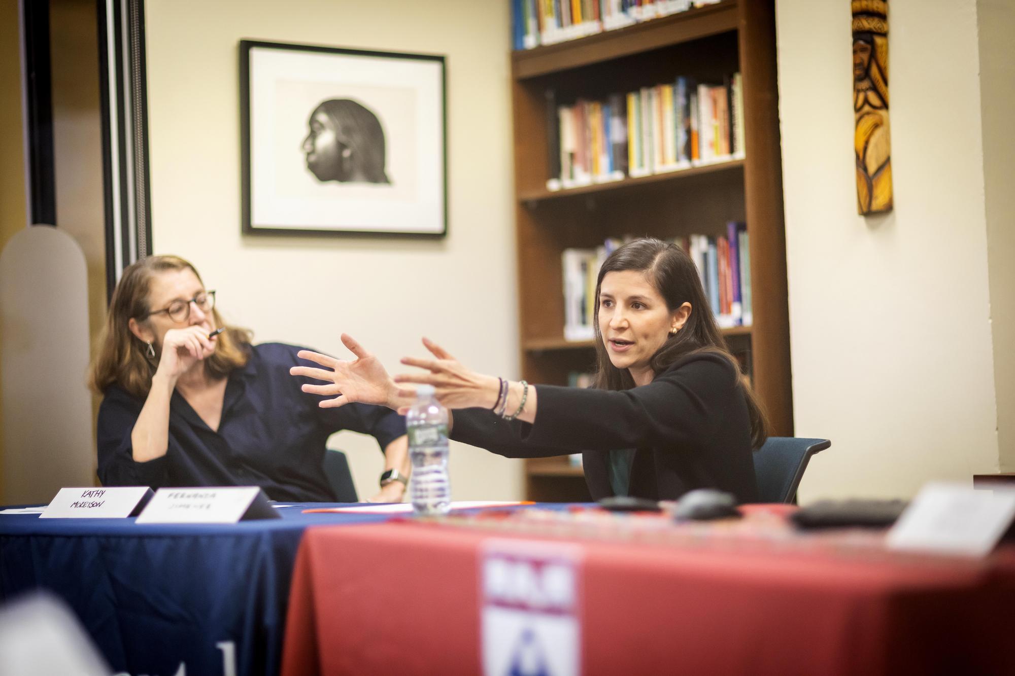 Kathleen Morrison listens as Fernanda Jiménez presents, her arms outstretched