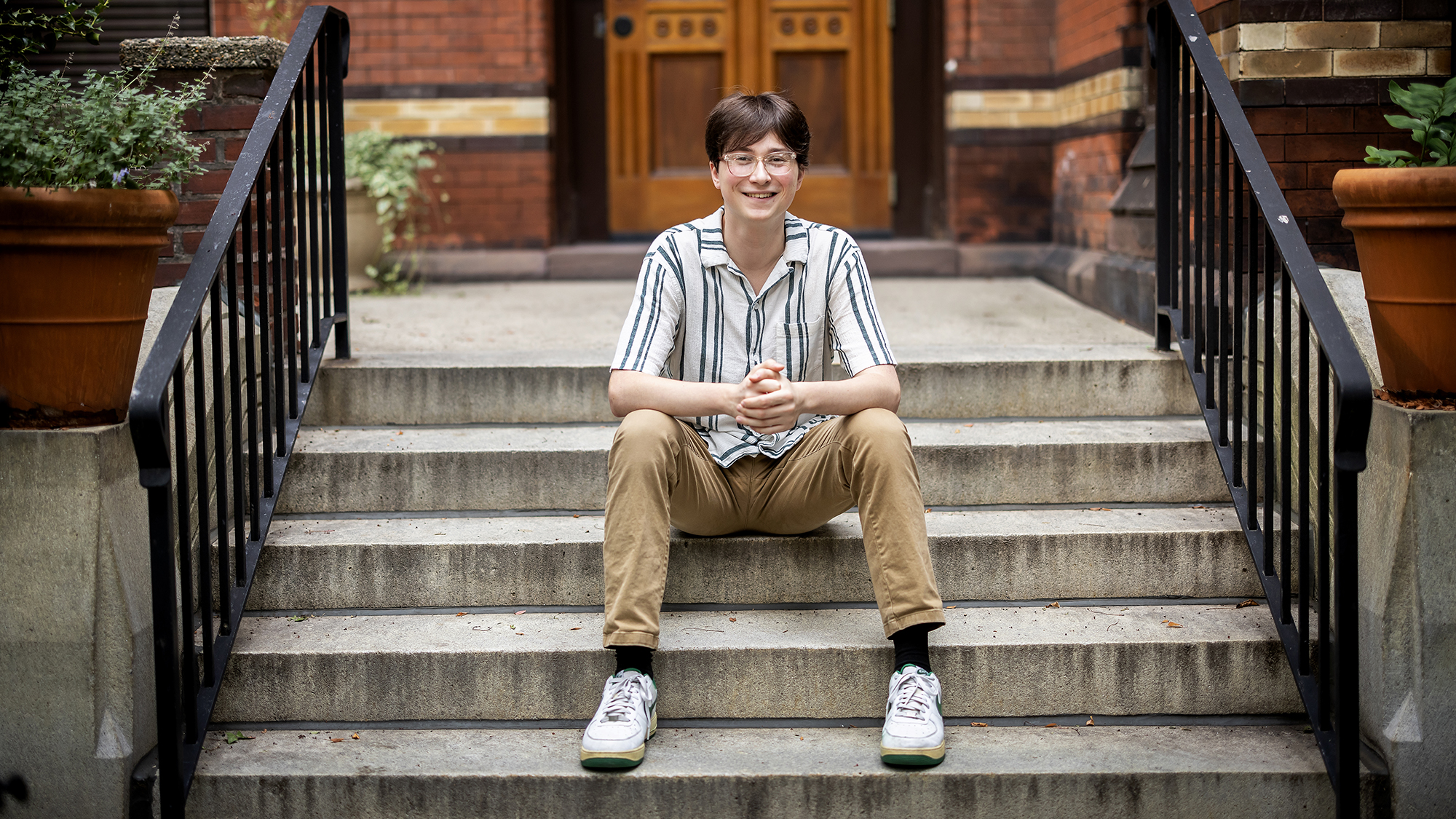 Dylan Fritz sits on the steps outside Penn Press.