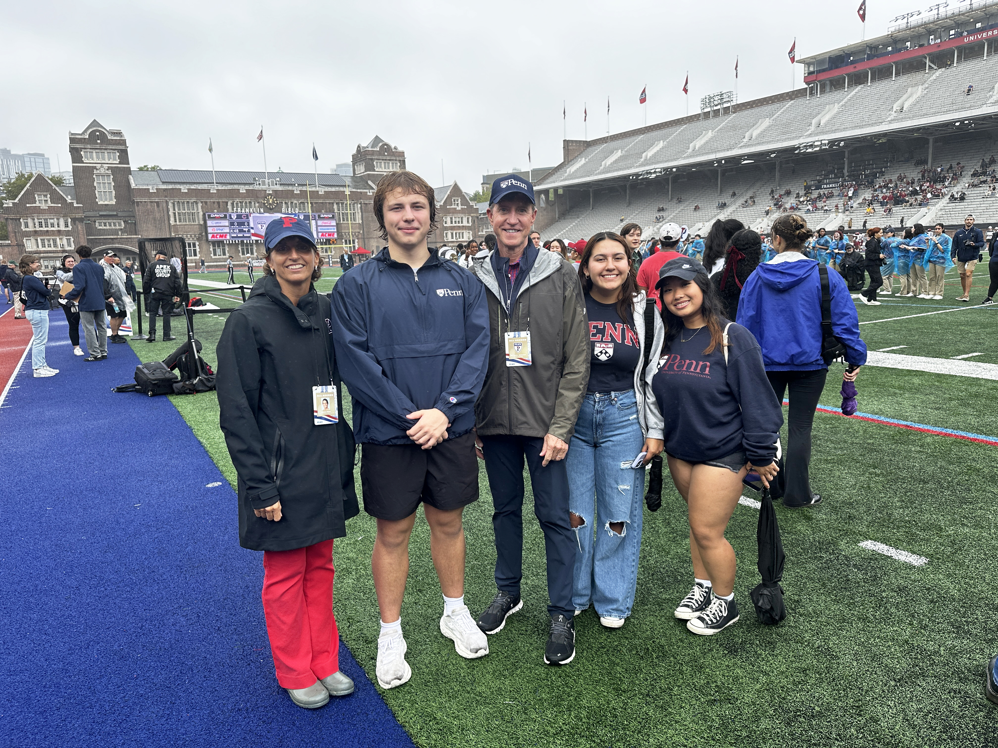 From left, Athletic Director Alanna Wren, new Class of 2028 President Mert Kayabas, Interim President J. Larry Jameson, and two first-years who came out to cheer on the Quakers.