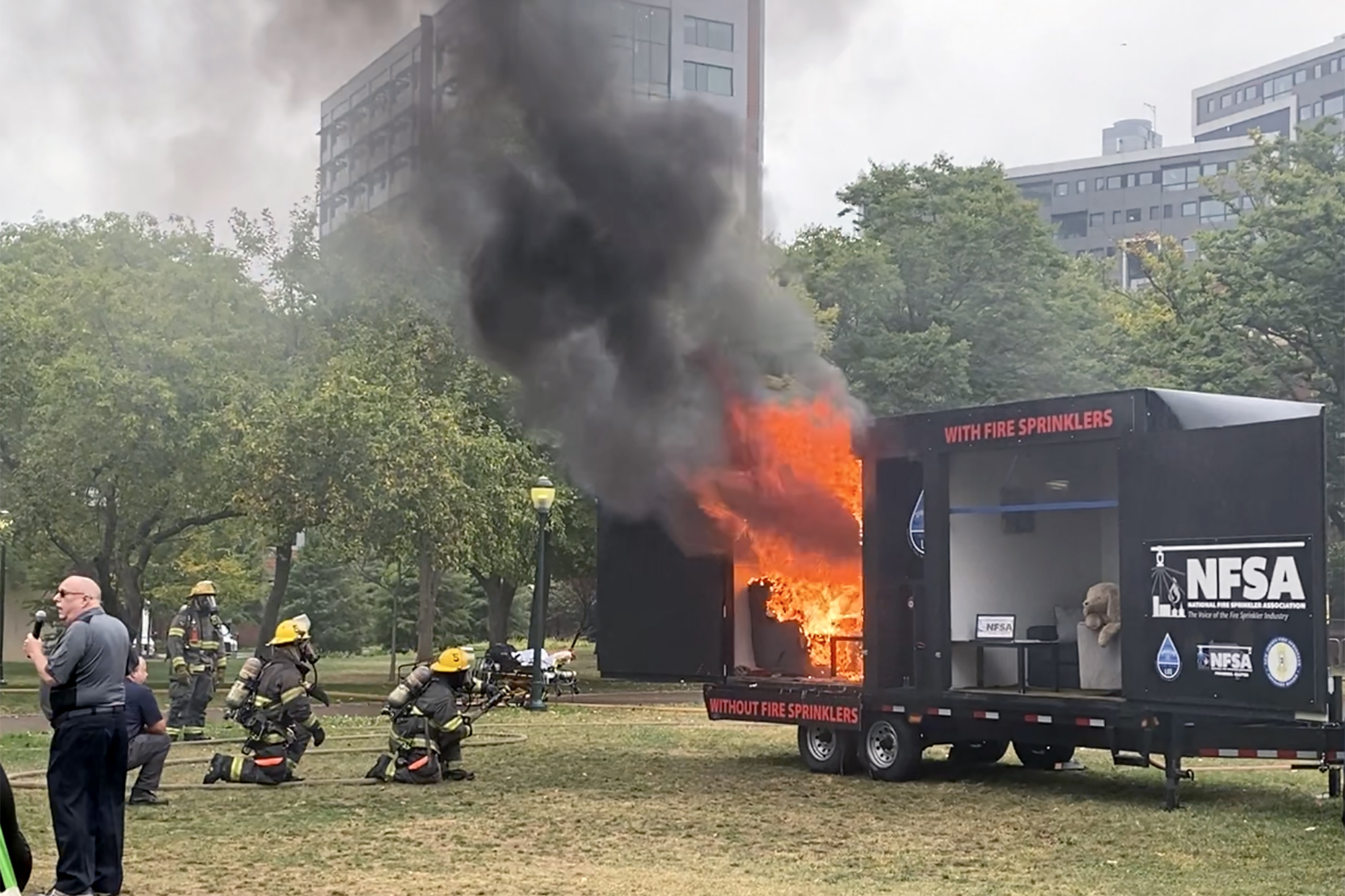 Firefighters wait to put out a controlled burn of a dorm room replica on Penn’s campus during DPS’s controlled burn event.