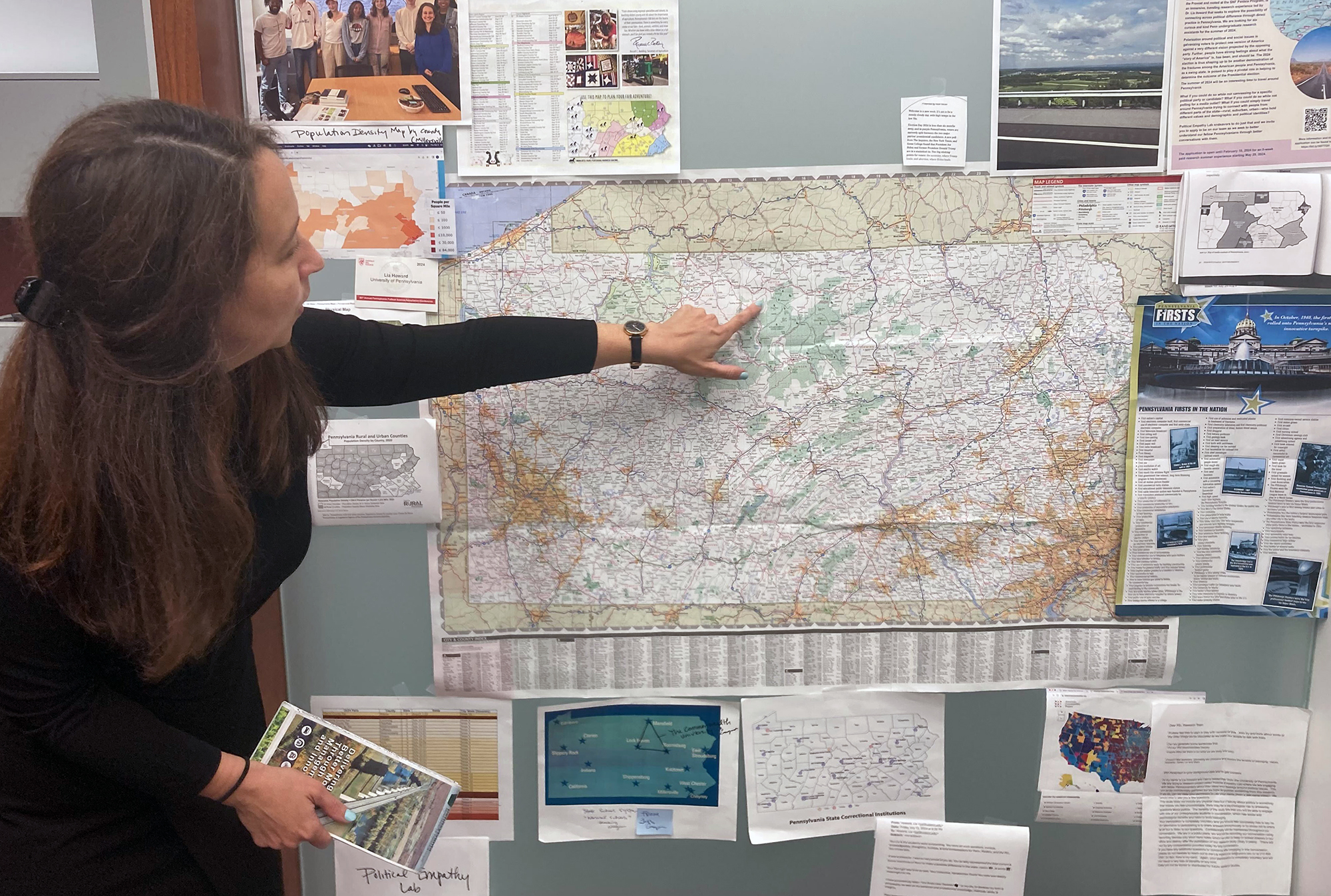 A member of the Political Empathy Lab points to a map on the wall.