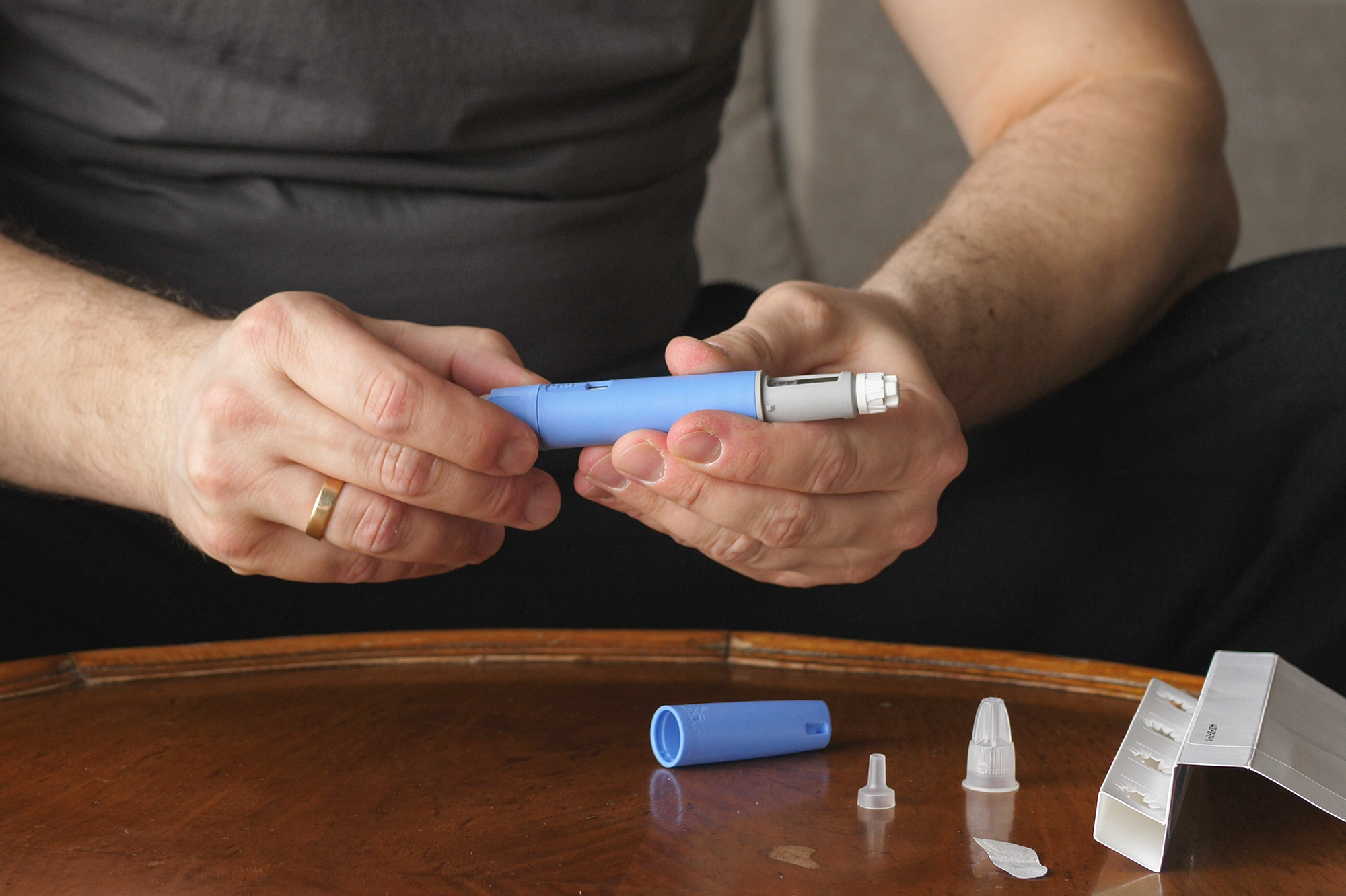 A person opening the top of a semaglutide prescription pen.