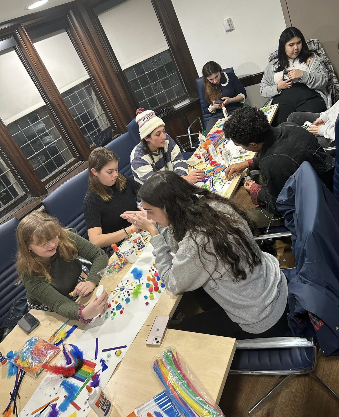 A group of students crafts at a long table