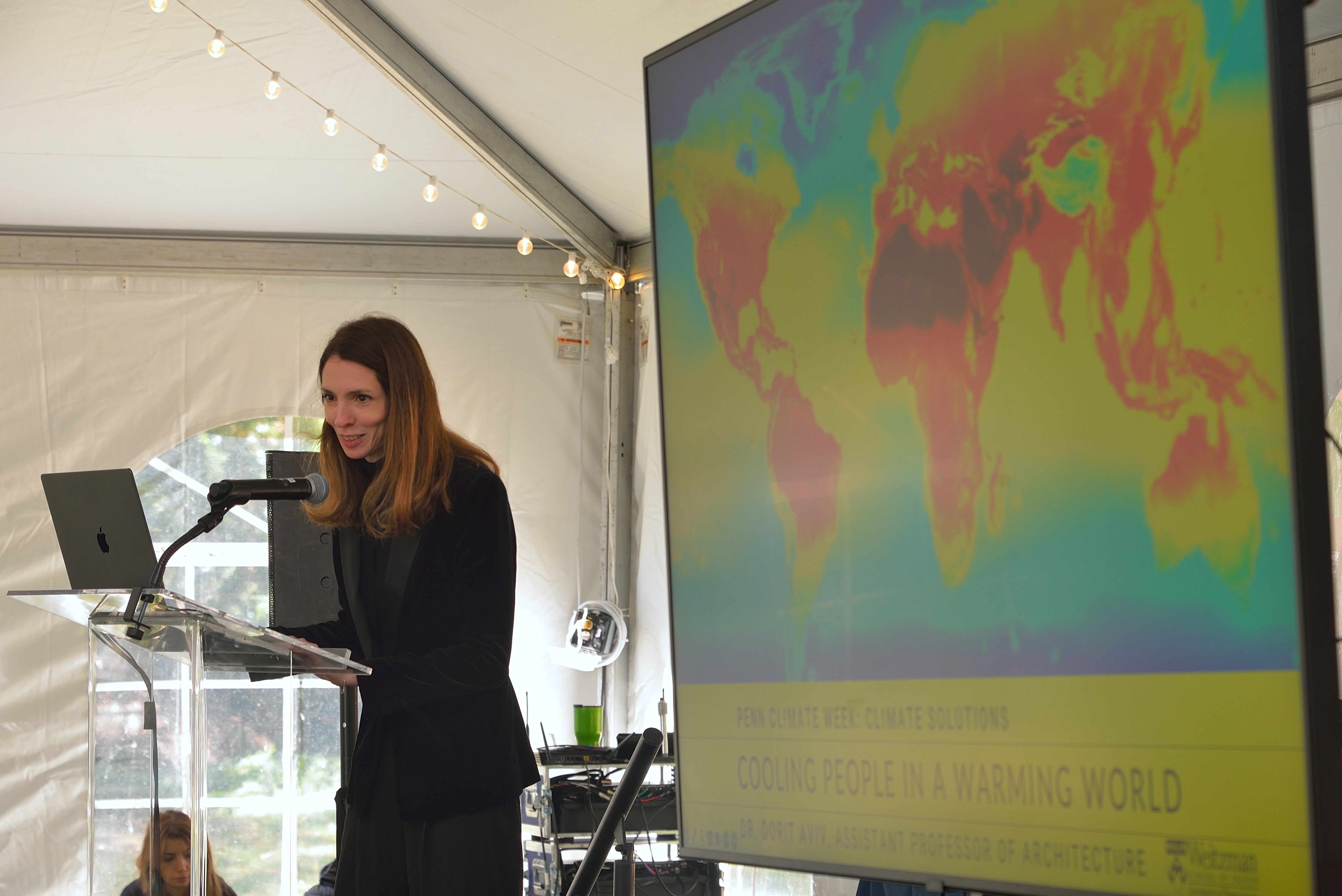 Dorit Aviv stands in front of a monitor displaying climate models.