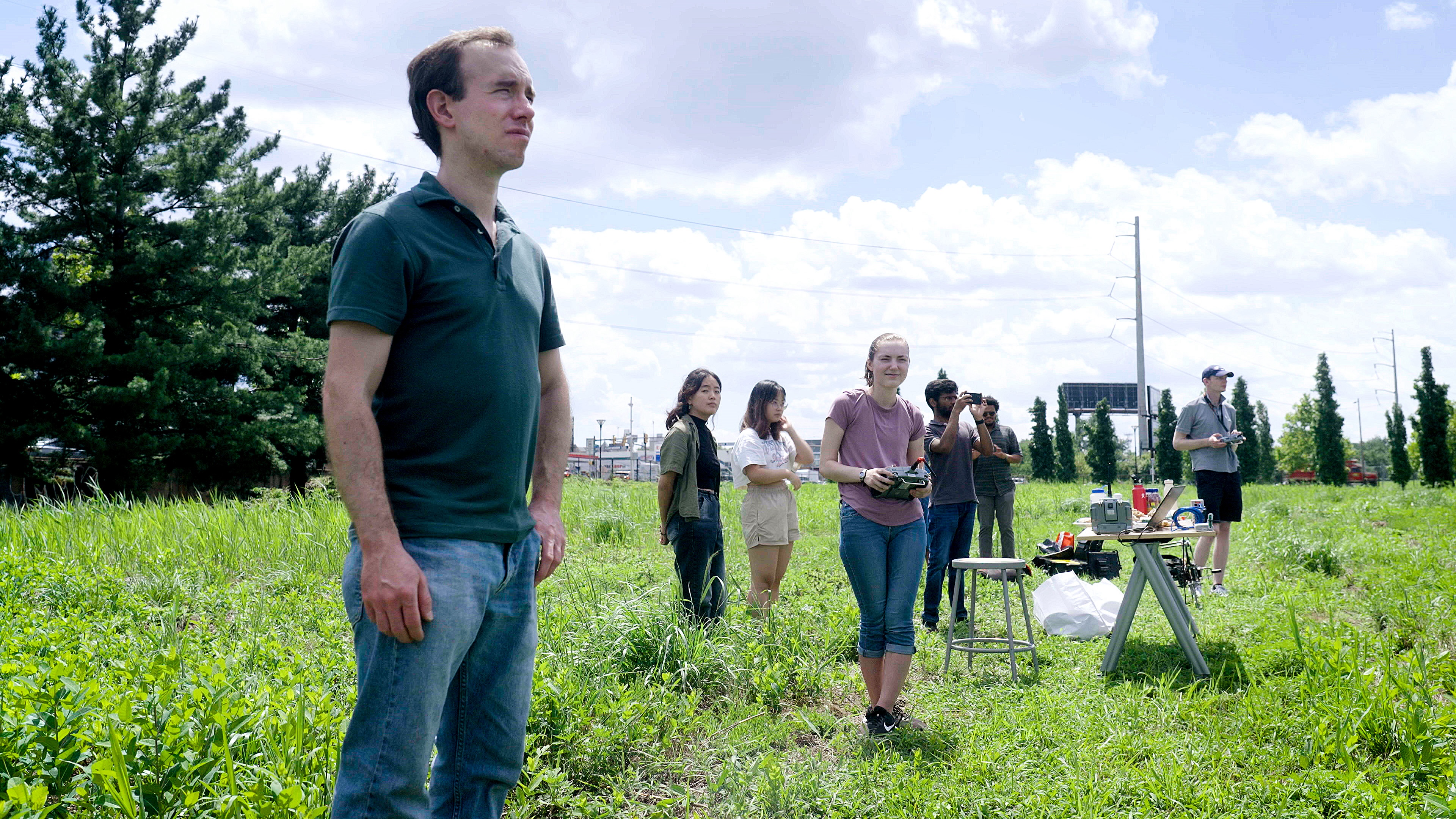 Eric Eaton standing in afield looking out at a drone.