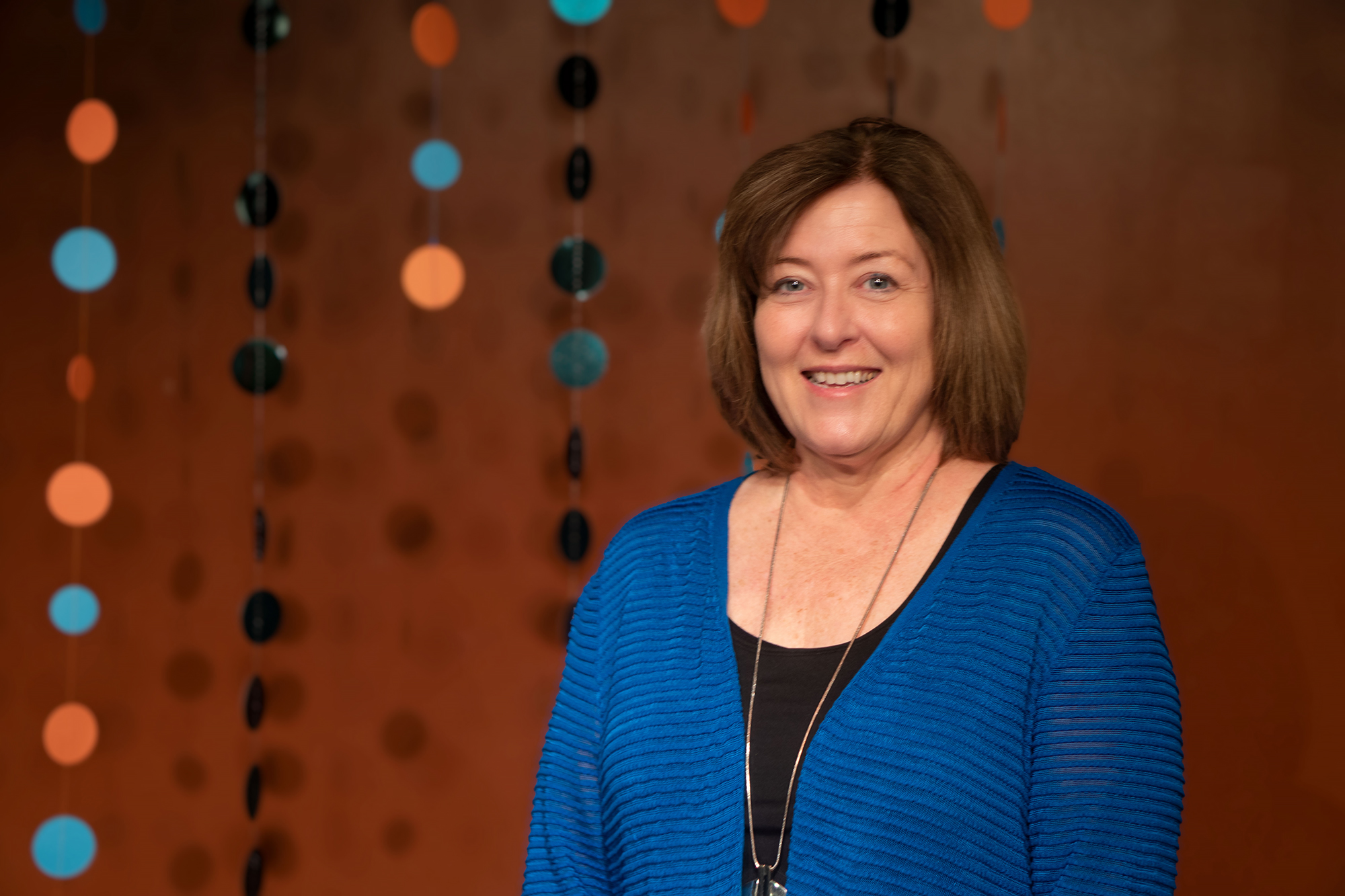 Laurie McCall standing in front of a mural