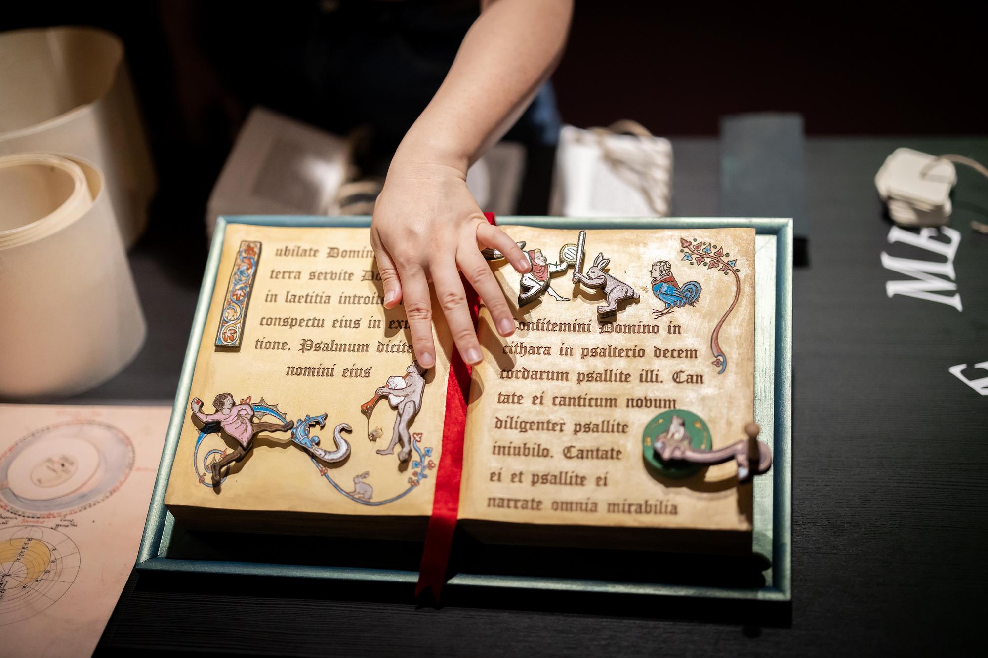 a hand on a hand-made book with moveable parts 