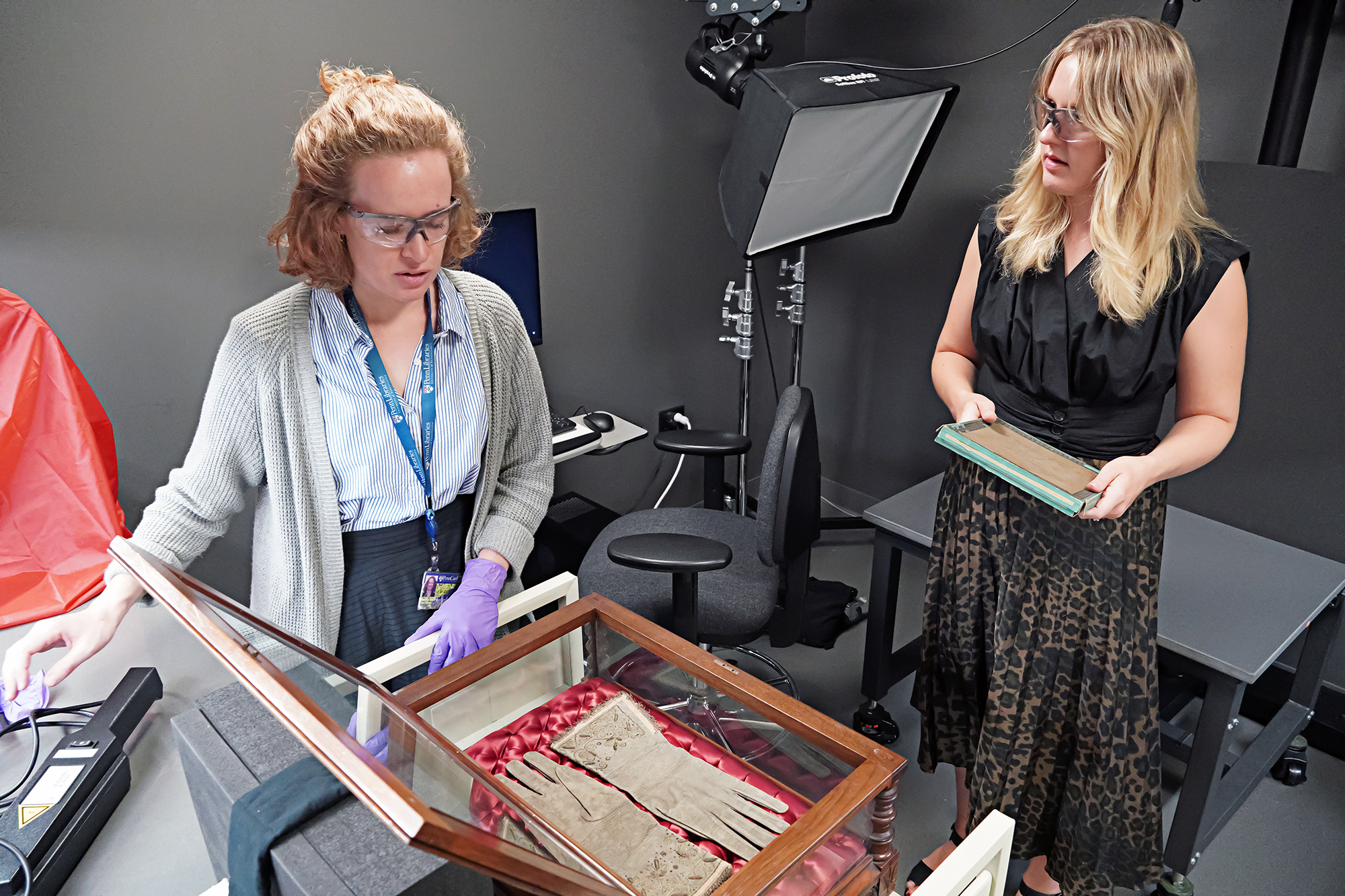 Two researchers preparing to scan historic gloves for carbon dating.