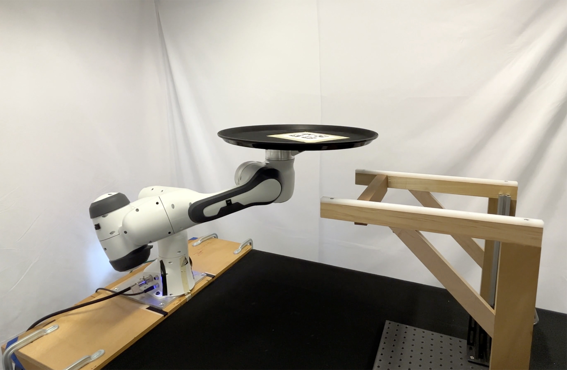 A robotic arm balancing a tray in a lab.