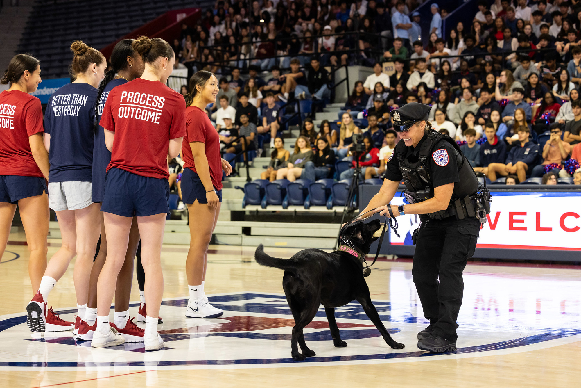 A police officer with a working dog on court at Penn’s Palestra.