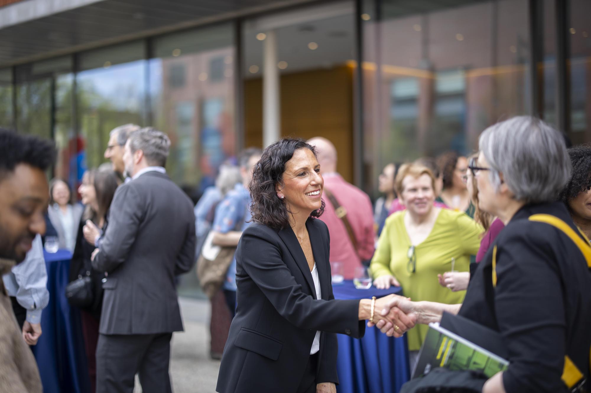 Dean Katharine Strunk shakes hands with another person.