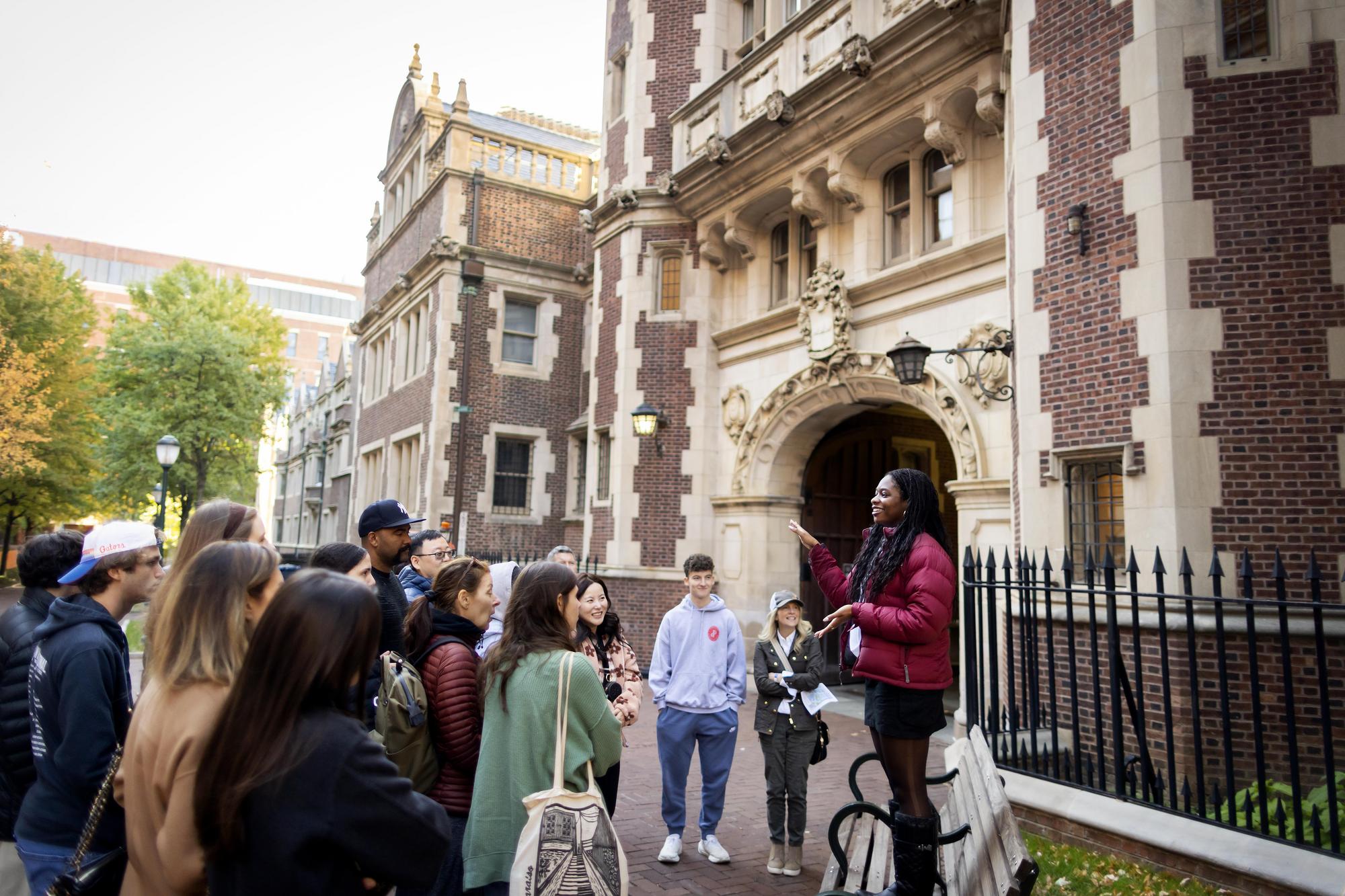 A student addresses a crowd of perspective Penn students and their parents in front of a dorm at Penn’s Quadrangle.