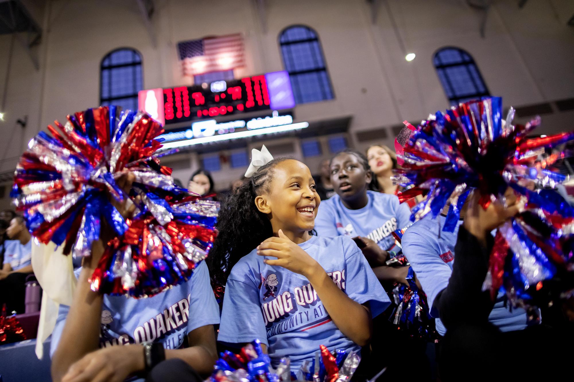 West Philadelphia students cheer on Penn Women's Basketball, waving pompoms