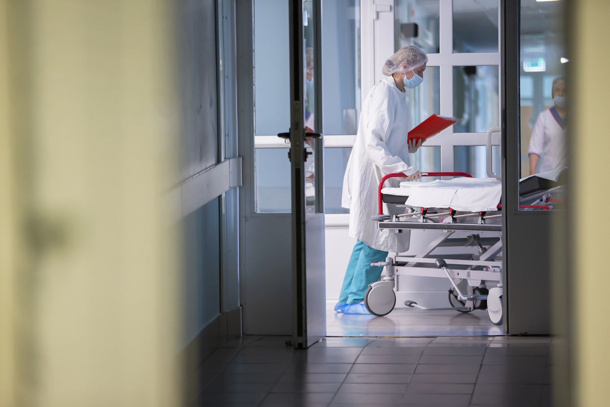 A nurse pushing a gurney in a hospital.