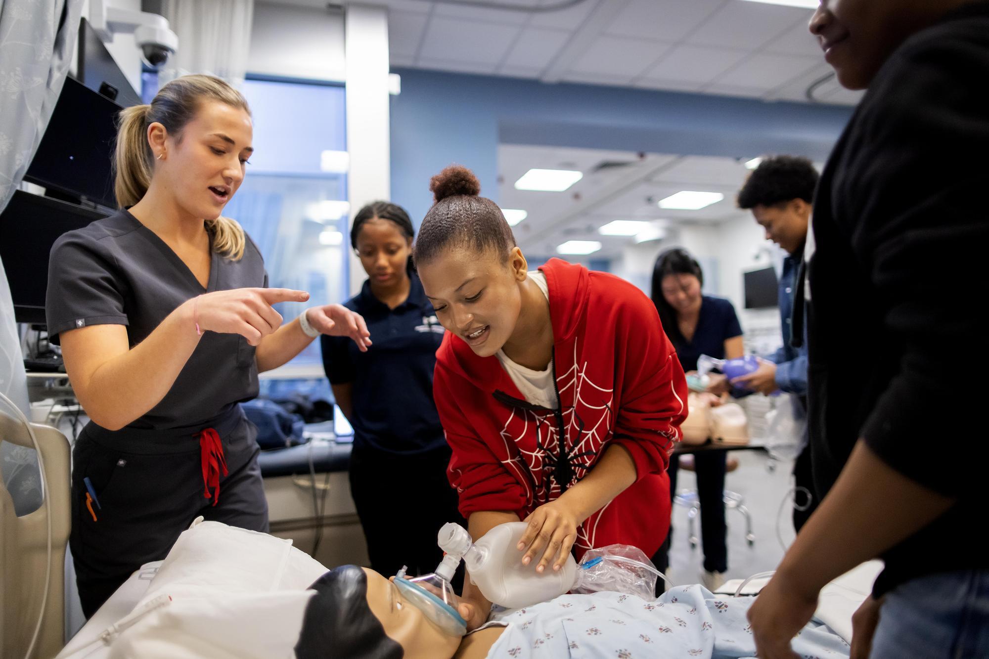 Charlotte Havens guides students on CPR.