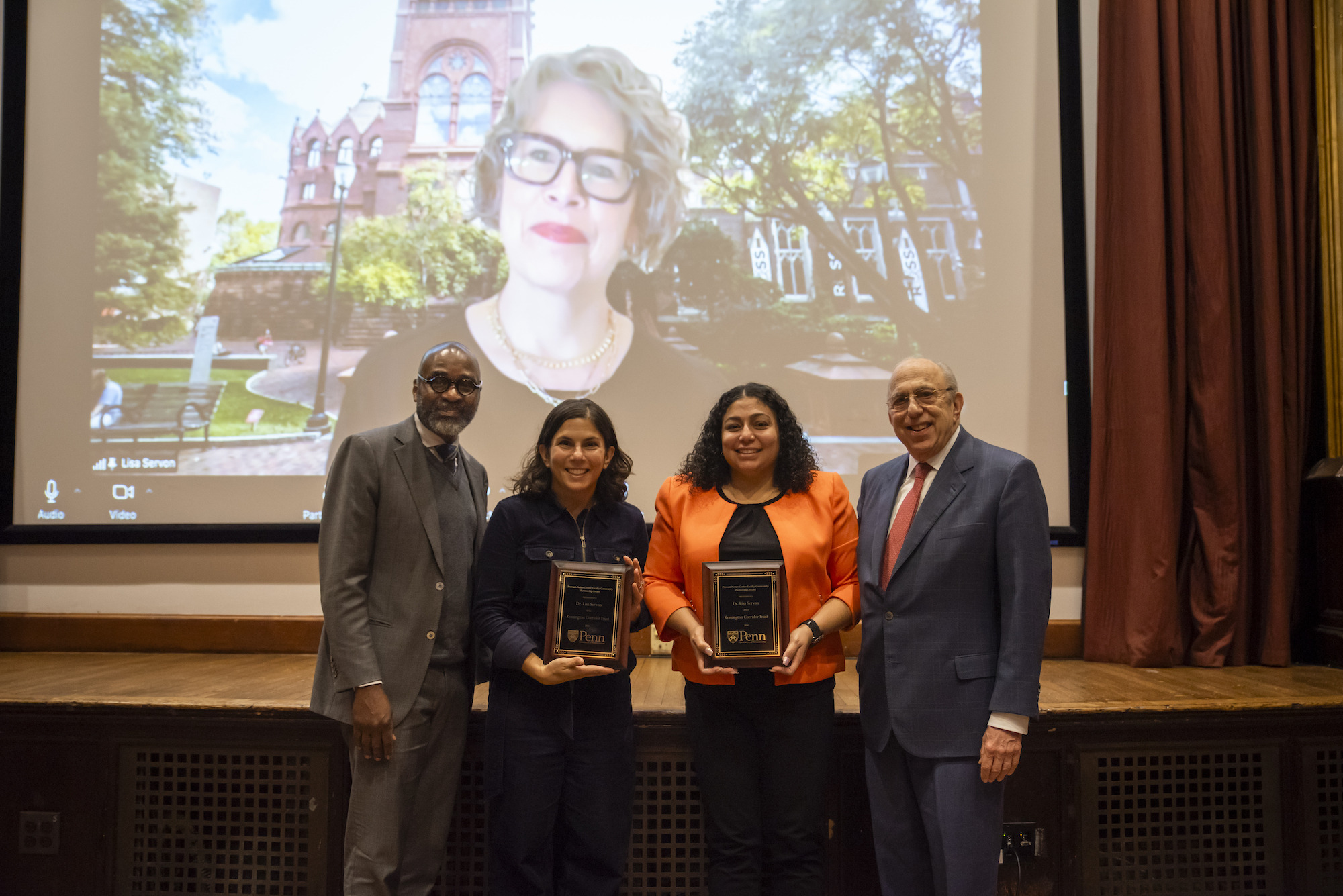 Provost John L. Jackson Jr. and Ira Harkavy stand with award recipients. In the background, Lisa Servon is on a Zoom screen