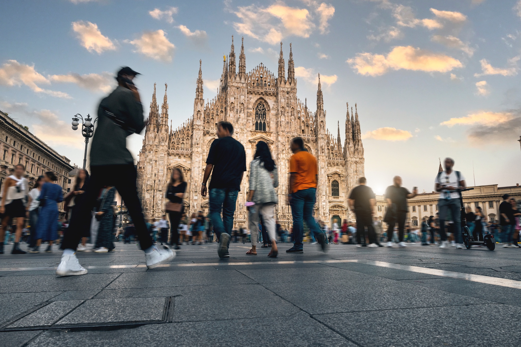 Blurred figures of people walk across a public square in Milano, Italy. 