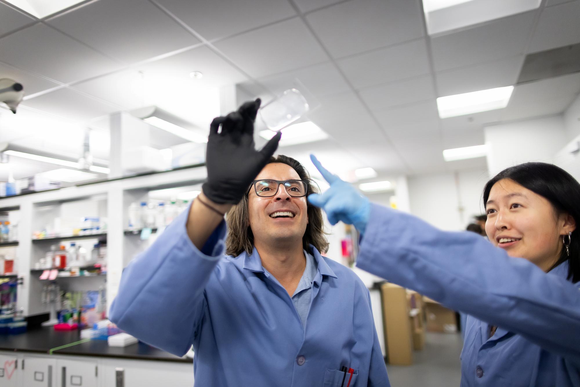 Michael Mitchell and partner holding a glass slide in the lab.