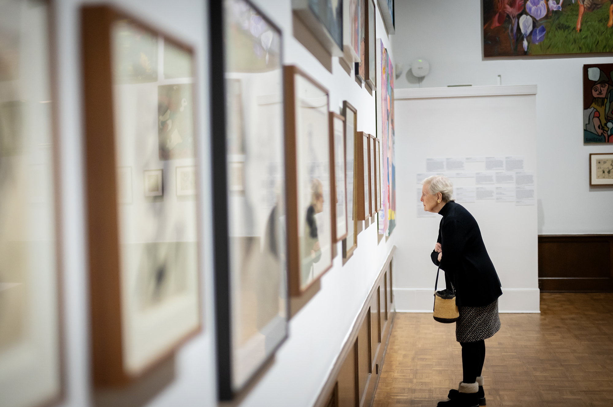 gallery attendee looking closely at art