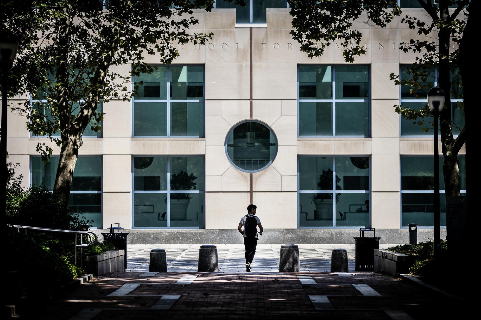 Annenberg School for Communication exterior and the silhouette of a student.