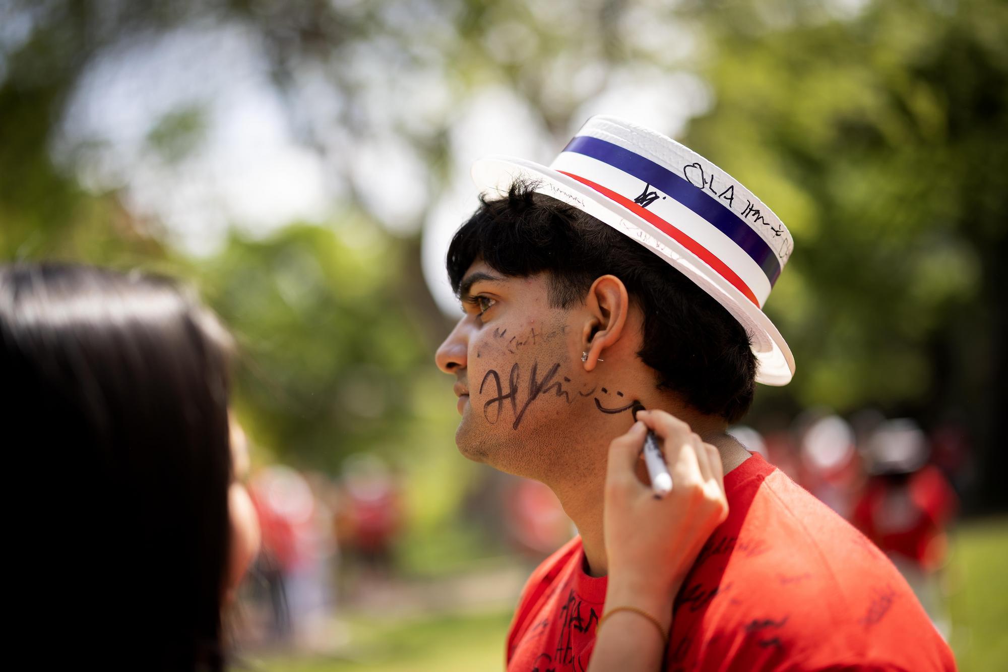 A student signing a friend’s face during Hey Day.