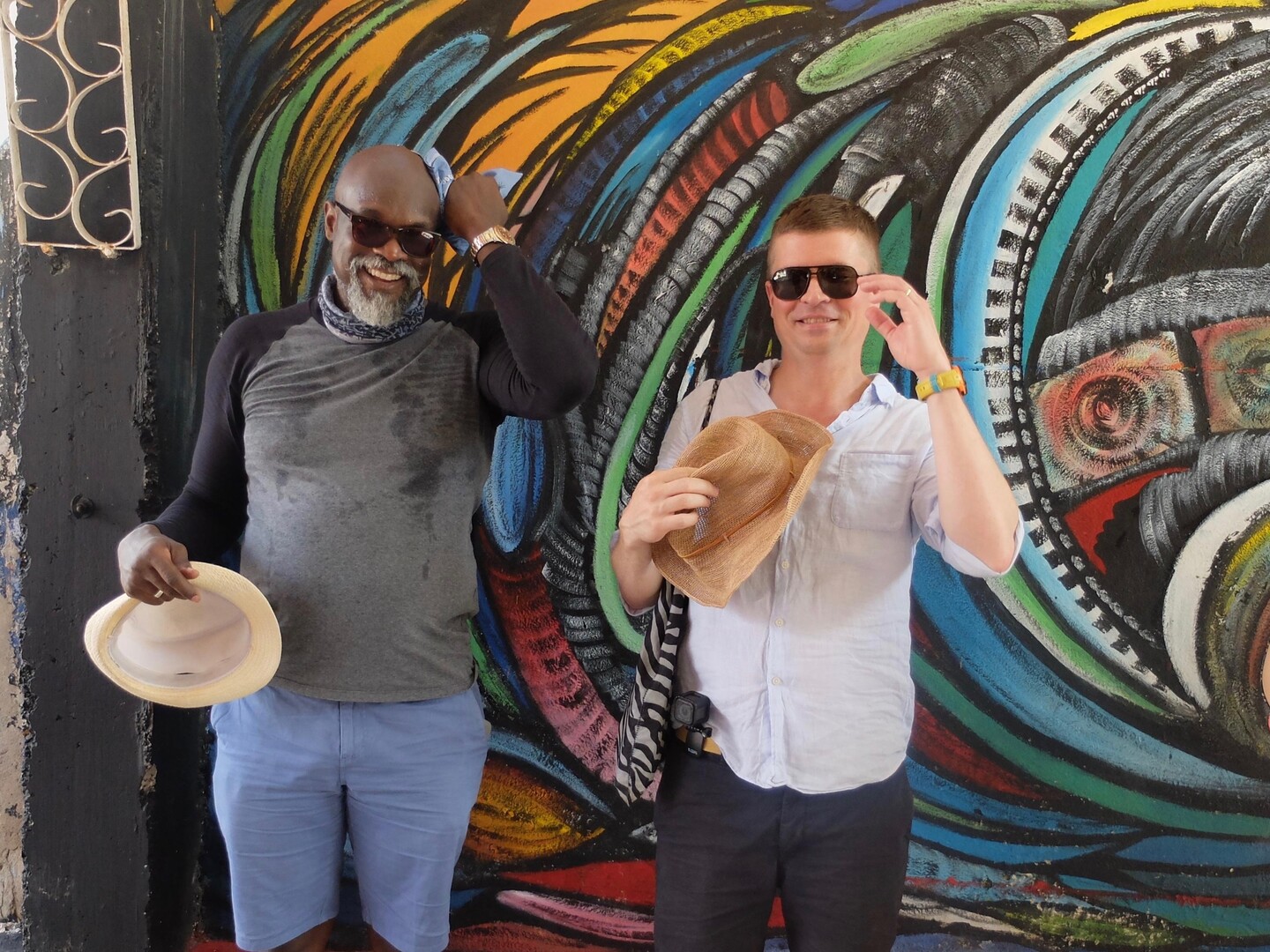 Portrait-of-Penn-Professor-Tukufu-Zuberi-and-Penn-PhD-Will-Schmenner-in-Cuba-in-front-of-colorful-mural. 