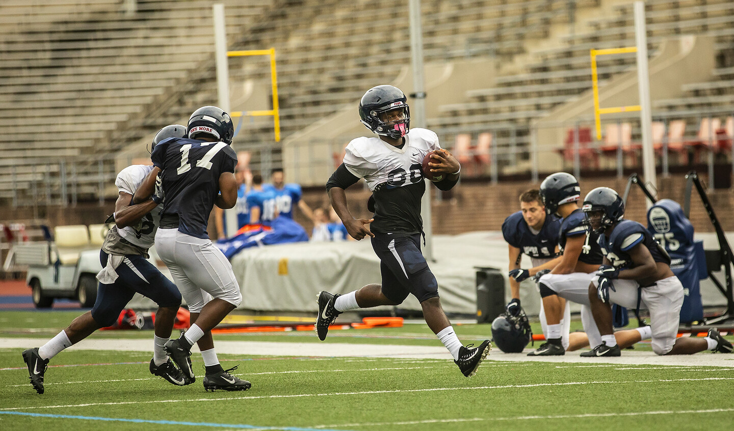 brooks-running-with-football-on-field