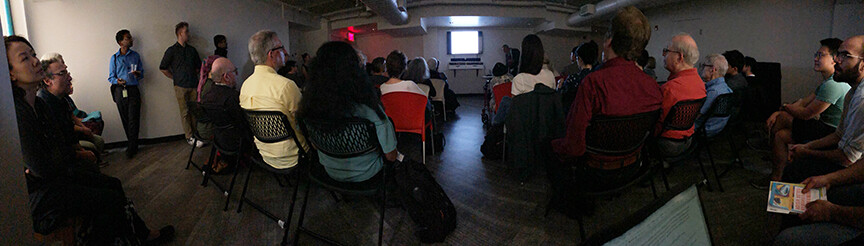 the back of an audience in a dark lecture room