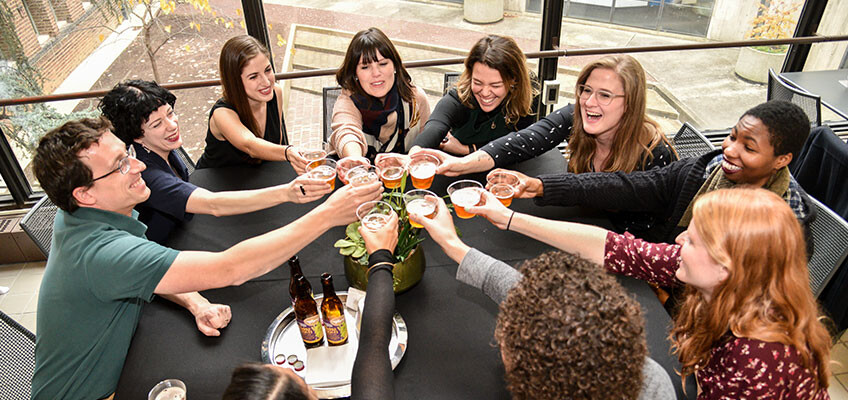 Group of people doing a cheers with beer