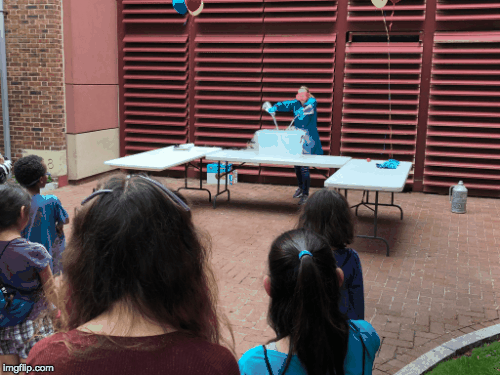 a cloud emerging from a plastic container full of dry ice