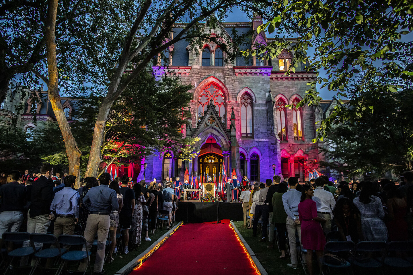 College Hall at dusk lit with colorful lights. 