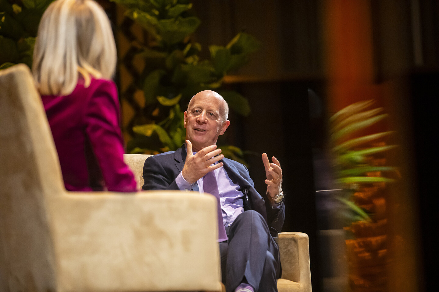 Paul Goldberger sitting in chair speaking and gesturing with his hands. 