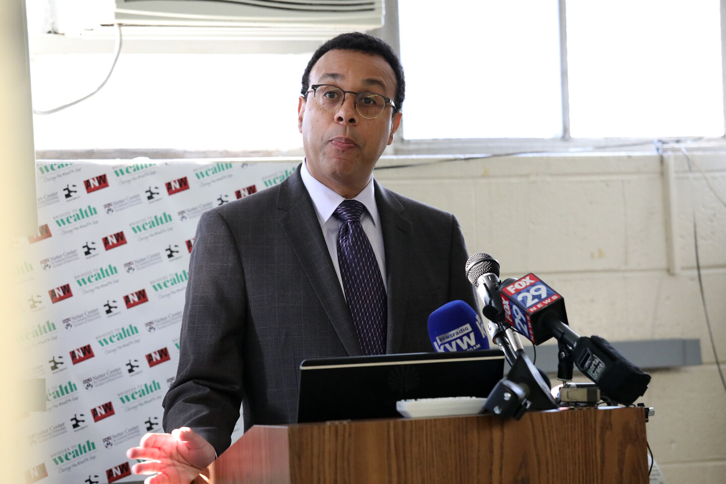 Provost Pritchett speaking at podium with media microphones