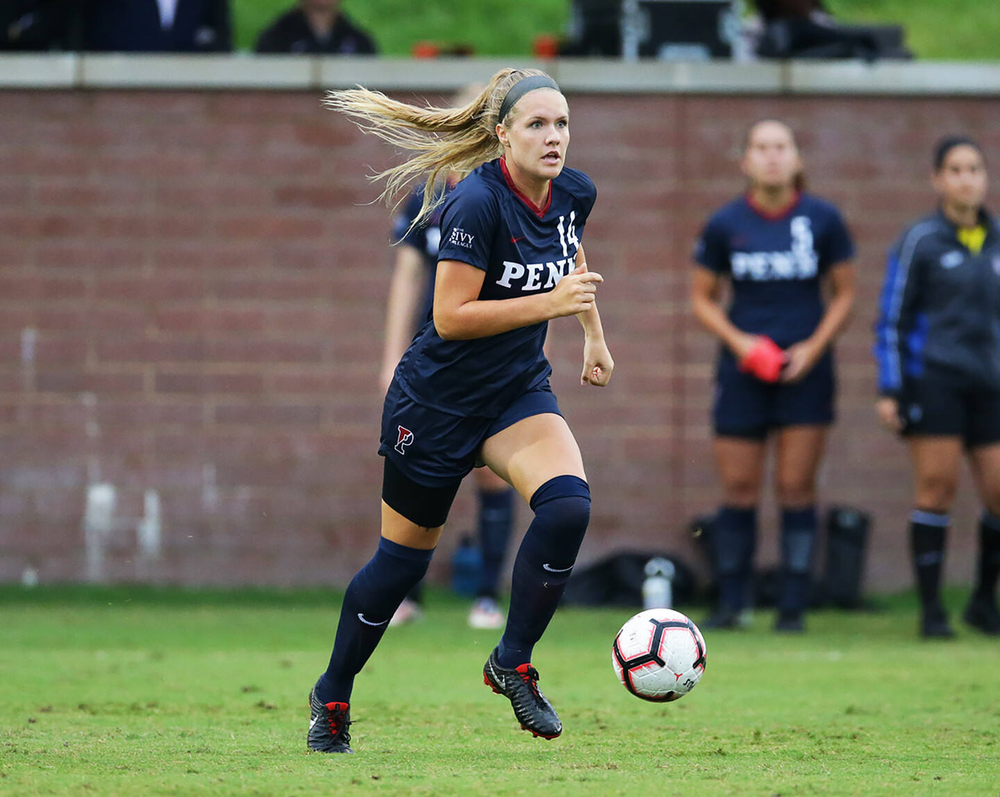 Mia Shenk of the women's soccer team dribbles the ball down the field.