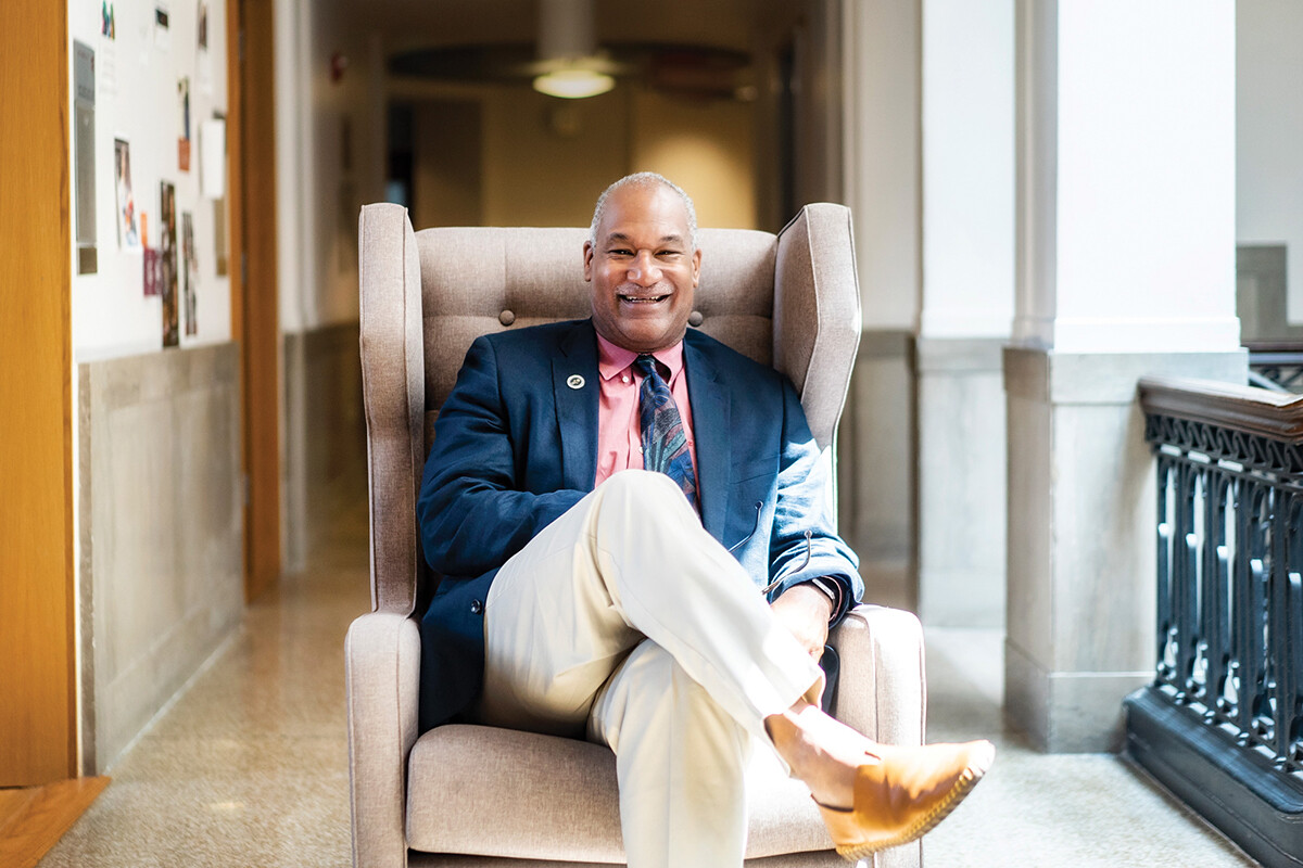 Herman Beavers sits in a recliner in a University hallway