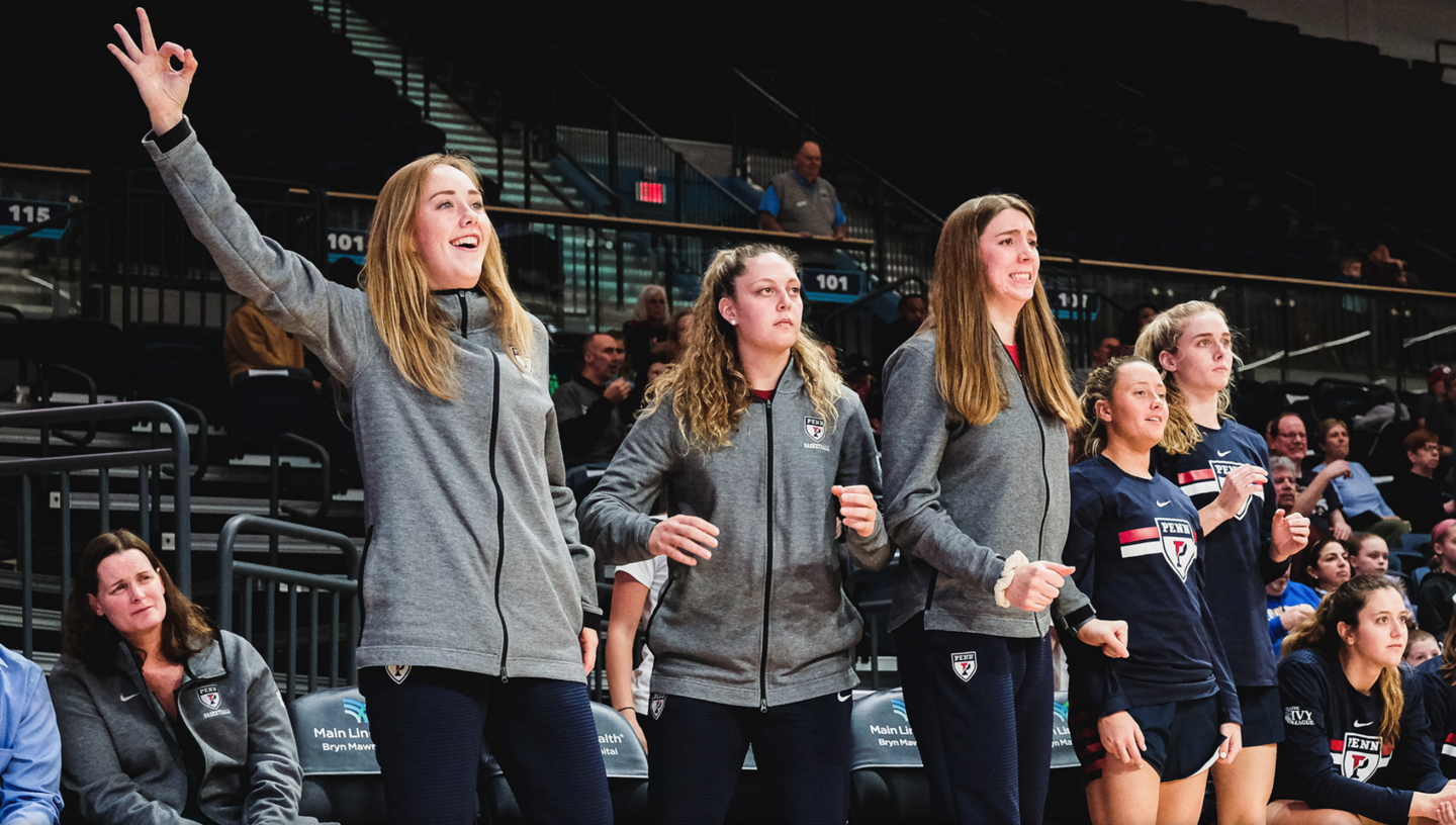 Standing on the sidelines, Liz Satter, left, cheers on her teammates during a game.