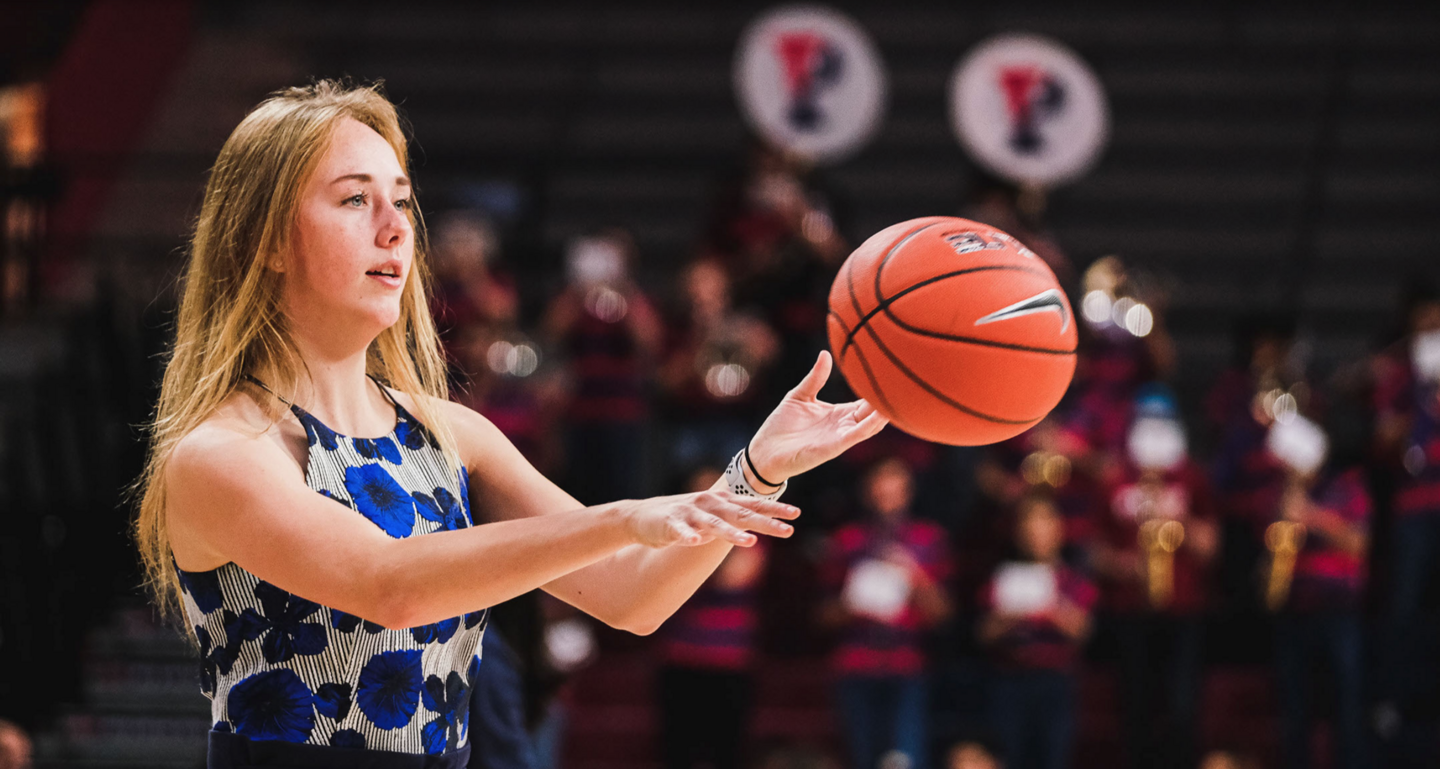 Wearing street clothes, Liz Satter passes a basketball.