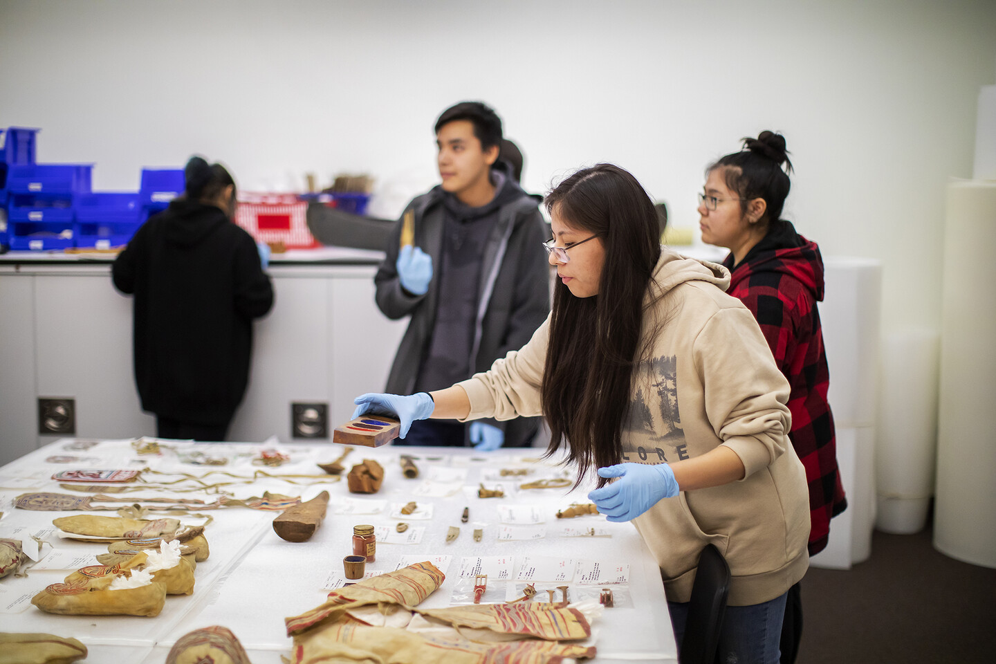 Student holds wooden paint pot.