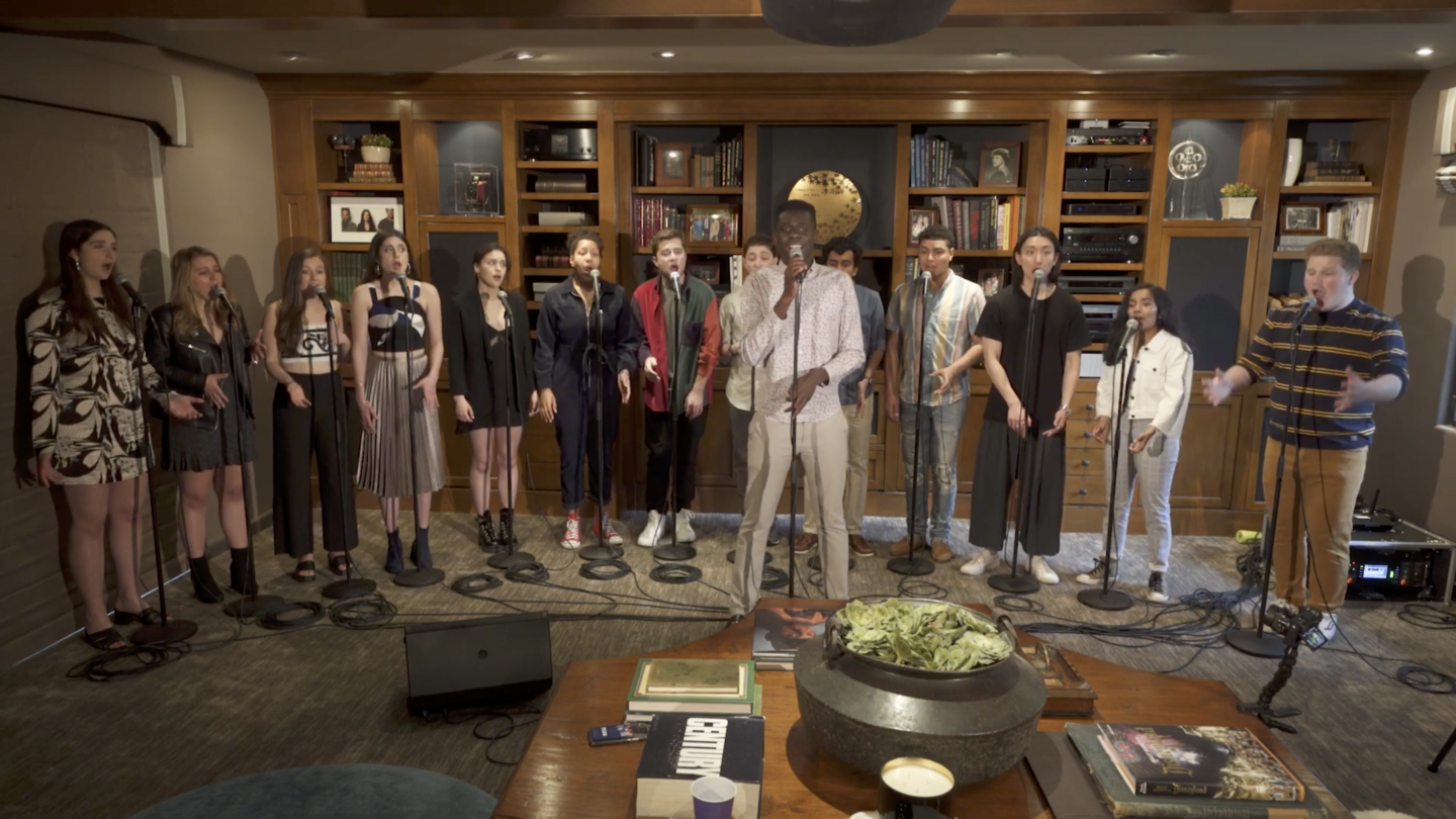 Fourteen students singing at microphones together. 
